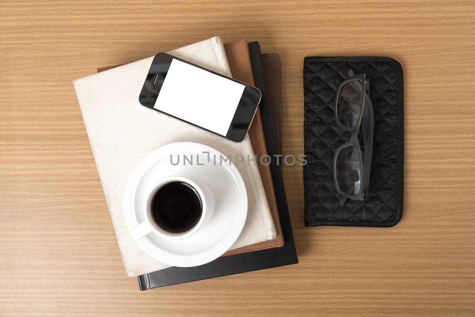 coffee,phone,eyeglasses,stack of book and wallet on wood table background