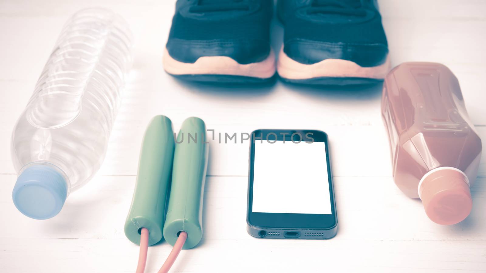 fitness equipment : running shoes,jumping rope,water,juice and phone on white wood background vintage style