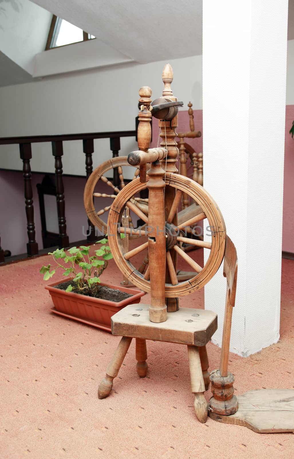 Nice ancient wooden spinning wheel in home interior