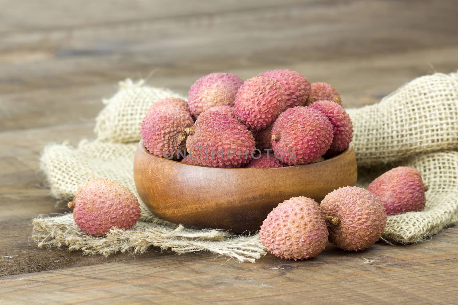 fresh lychees in a bowl  on wooden background by miradrozdowski
