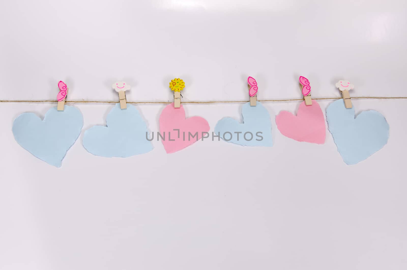 Beautiful paper hearts connected with a rope on white paper background.