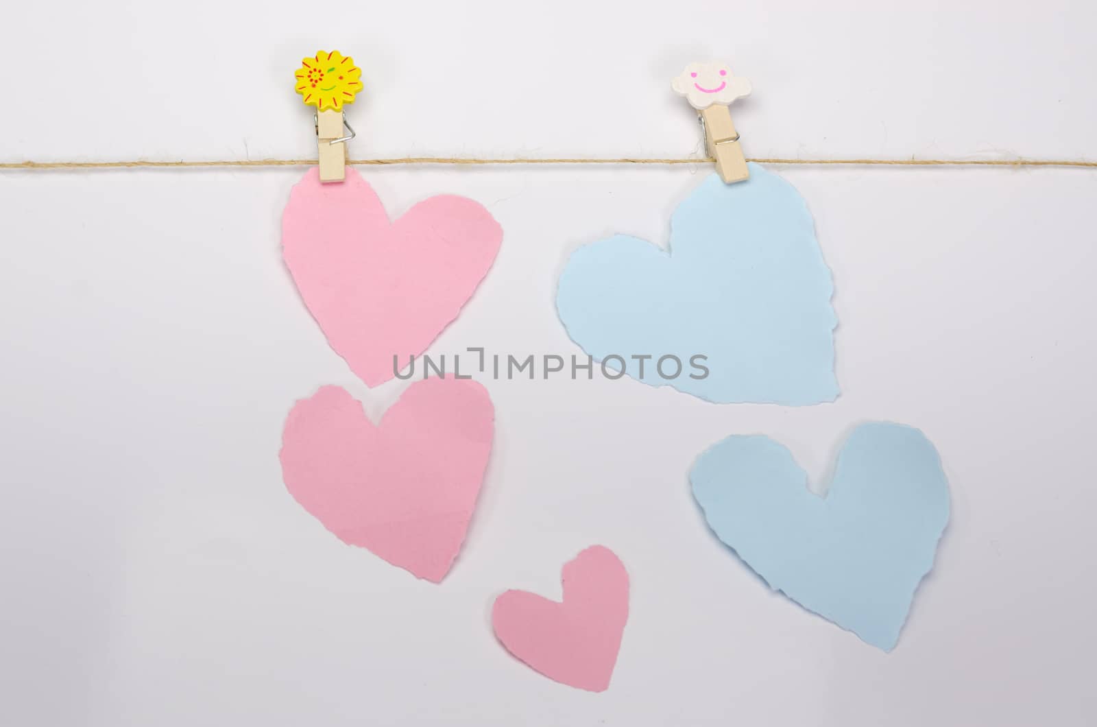 Beautiful paper hearts connected with a rope on white paper background.