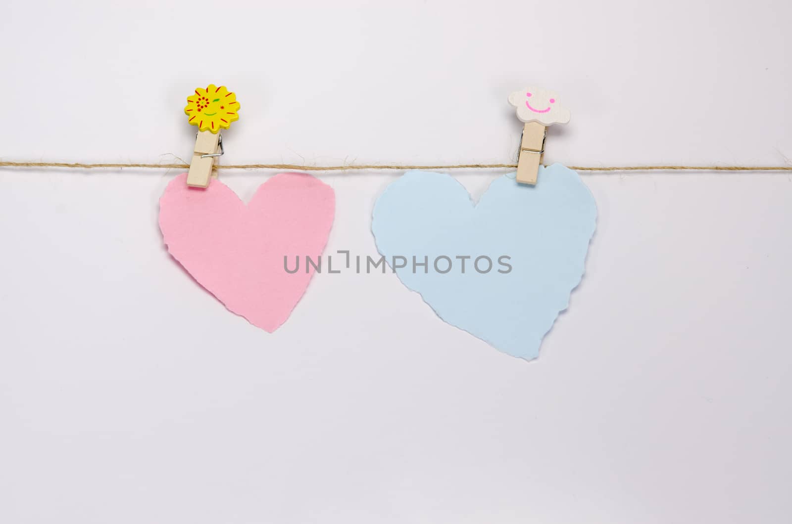 Beautiful paper hearts connected with a rope on white paper background.