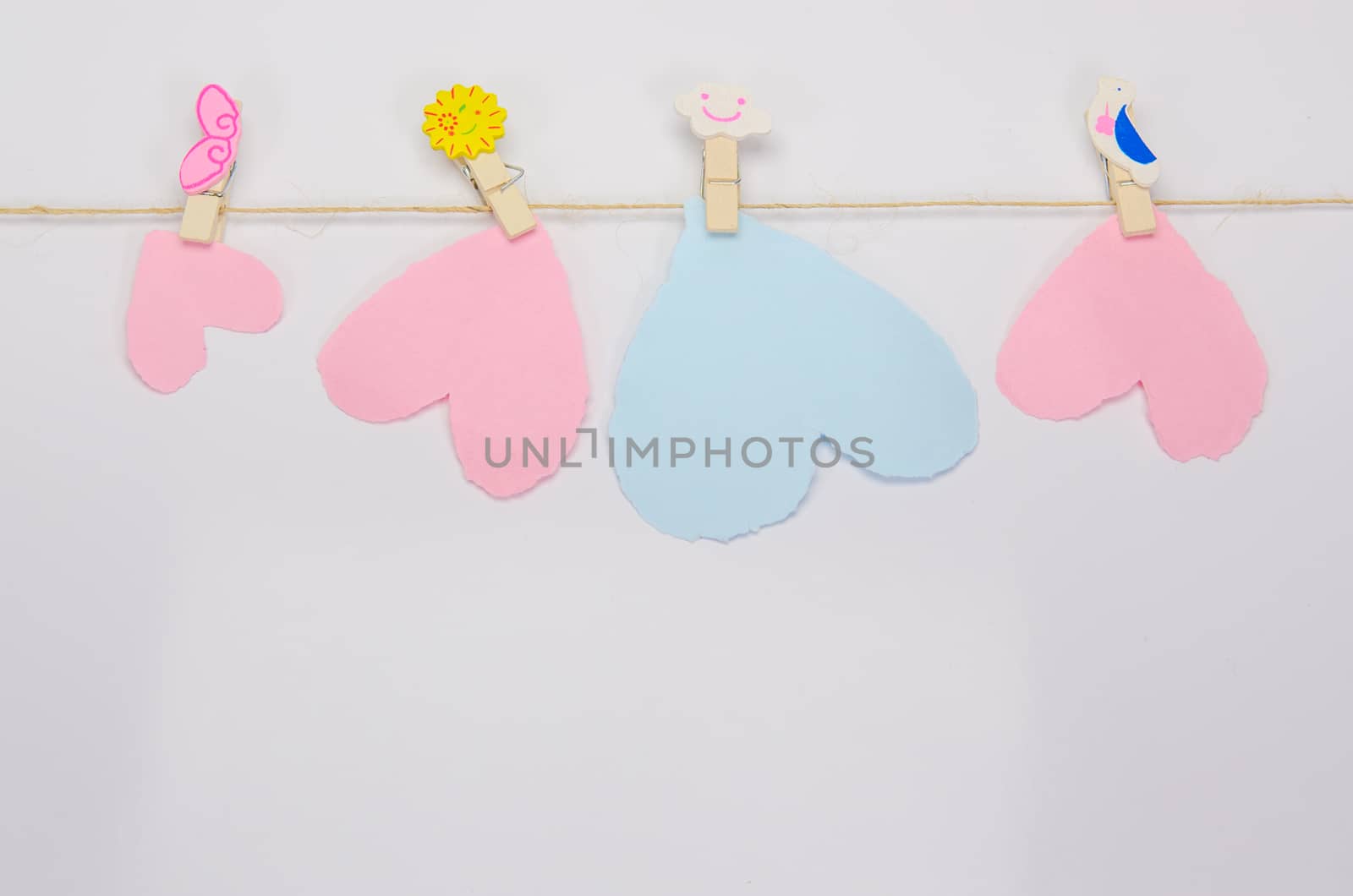 Beautiful paper hearts connected with a rope on white paper background.