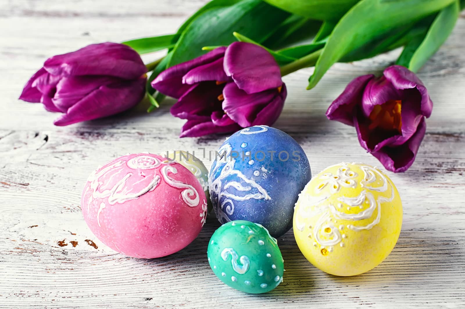 Decorated with painted Easter eggs and flowers on light background