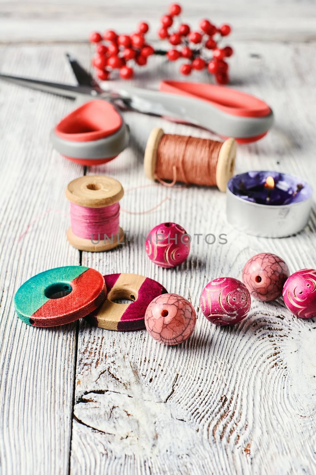 Beads and spools of thread for needlework on bright background