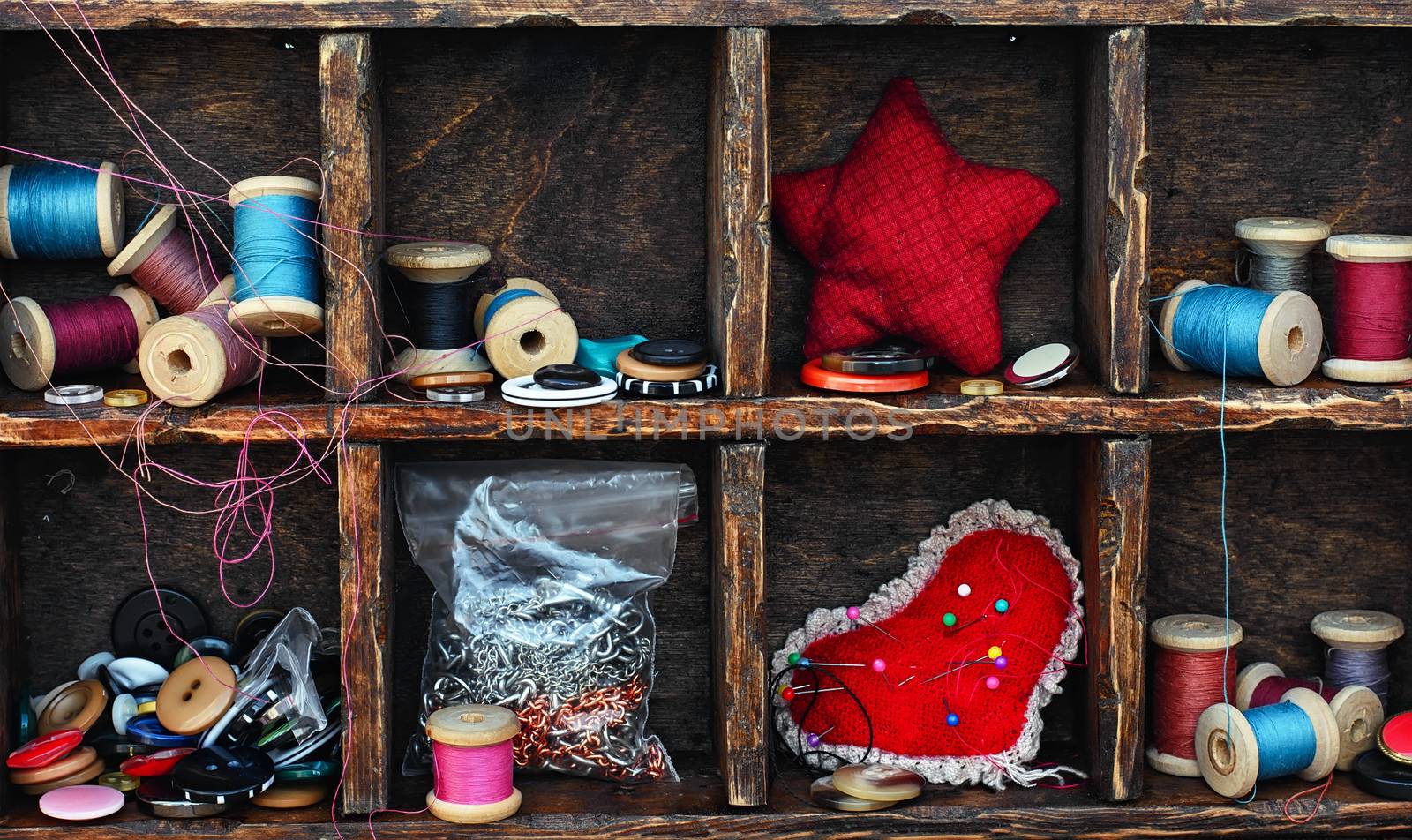 set for needlework from buttons,thread and needles within the cells in the wooden box