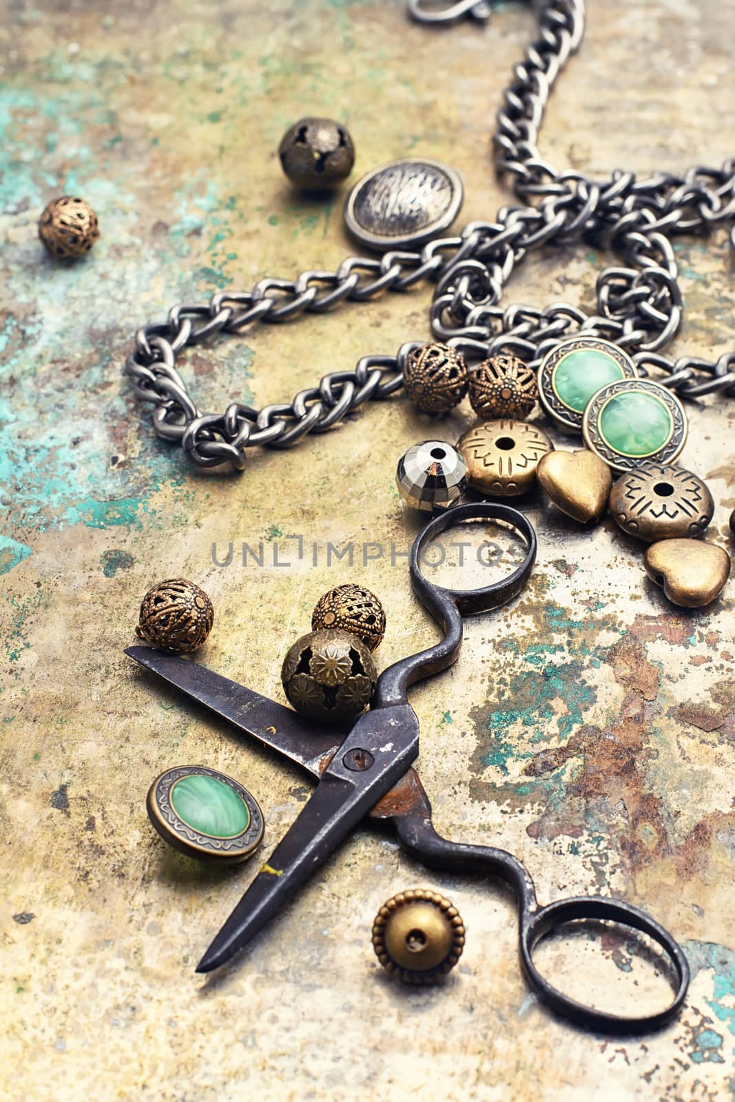 Metal beads,buttons,chain and scissors on retro background