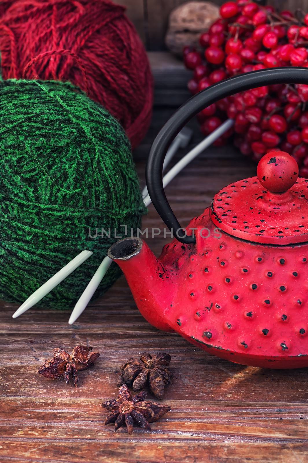Red and green ball of wool for knitting and red kettle.