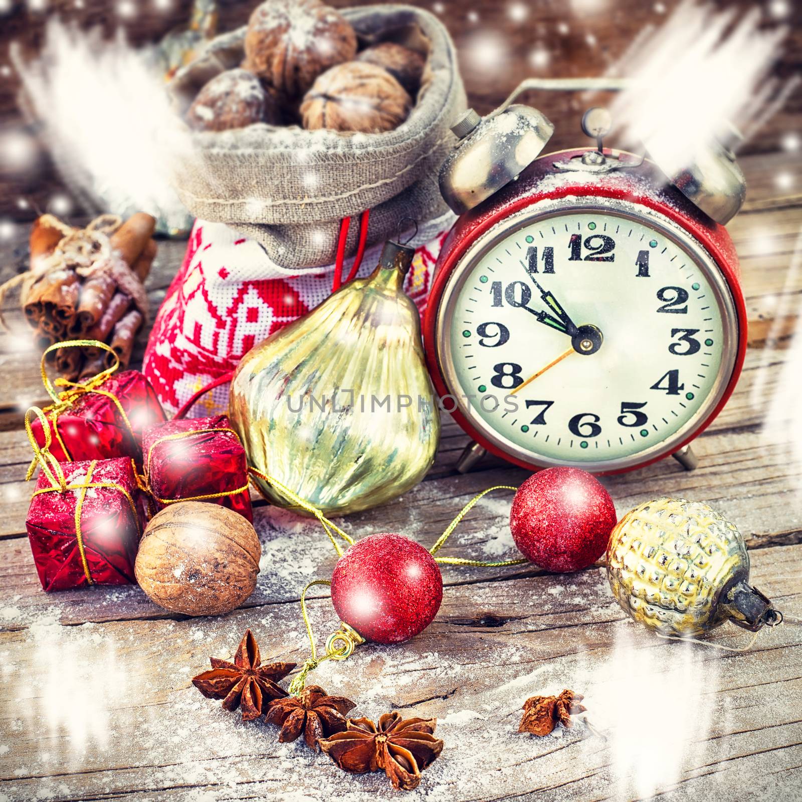 An alarm clock and bag of nuts on the background of Christmas decorations