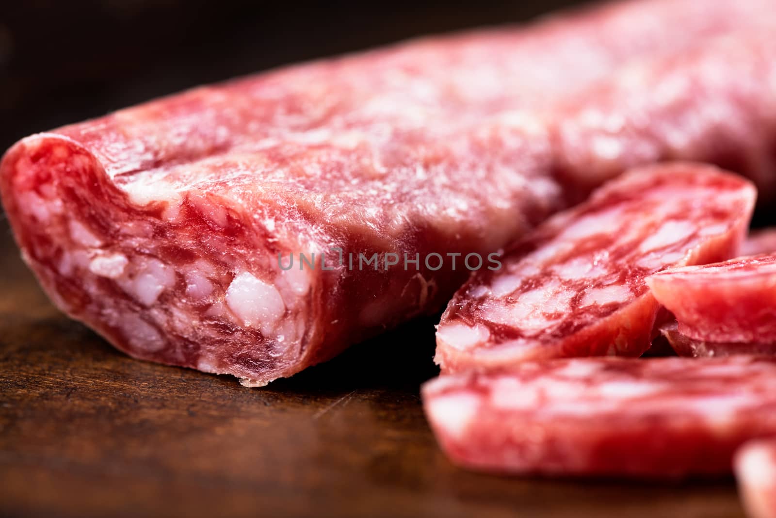 Spanish salami on wooden background close up