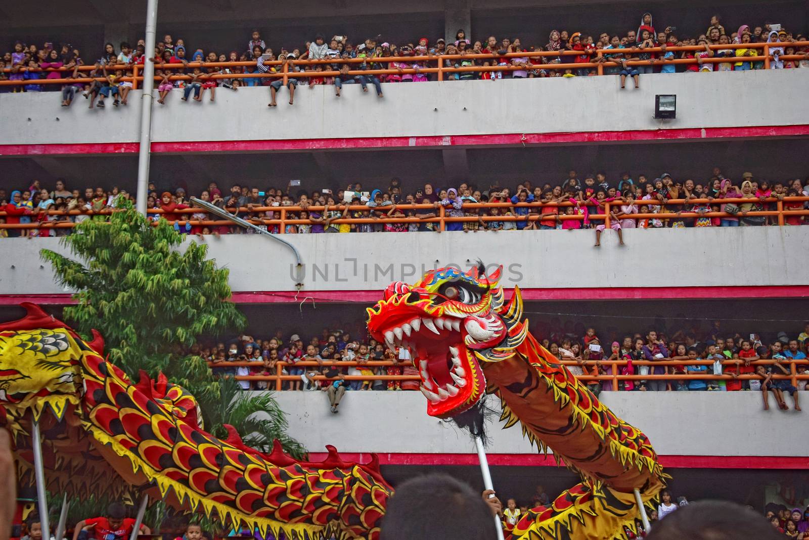 INDONESIA, Semarang: People gather around to watch the Lion dance, a traditional Chinese dance, behind Sri ratu mall, on Pemuda street, in Semarang, central Java, on the first day of the Lunar New Year in Kuala Lumpur's popular Chinatown area on February 8, 2016. The Lunar New Year is celebrated in many parts of the predominantly Muslim country of 250 million people where Chinese heritage took roots through ancient transmigration.