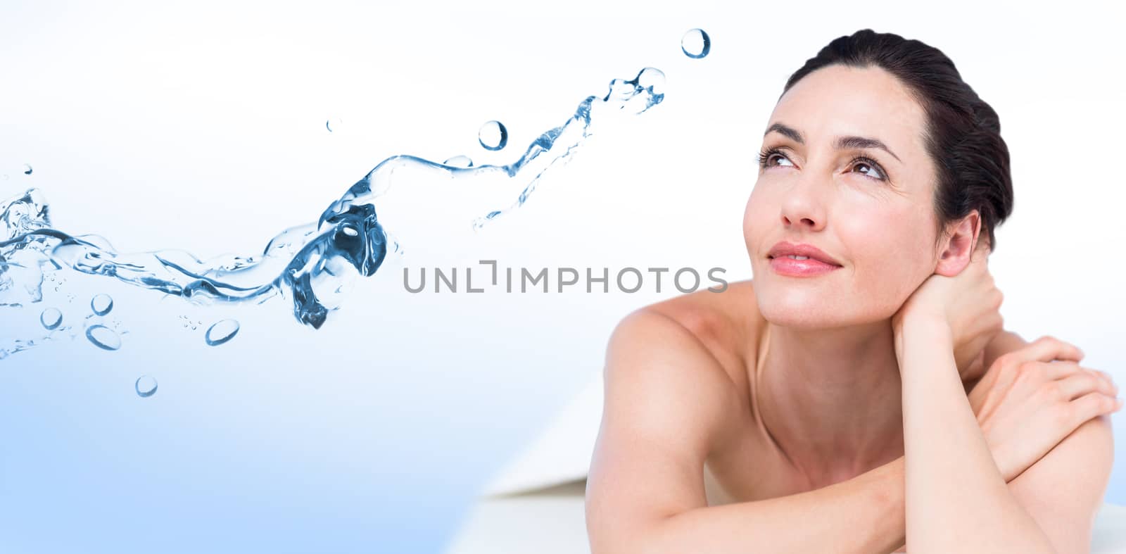 Composite image of smiling brunette relaxing on massage table by Wavebreakmedia