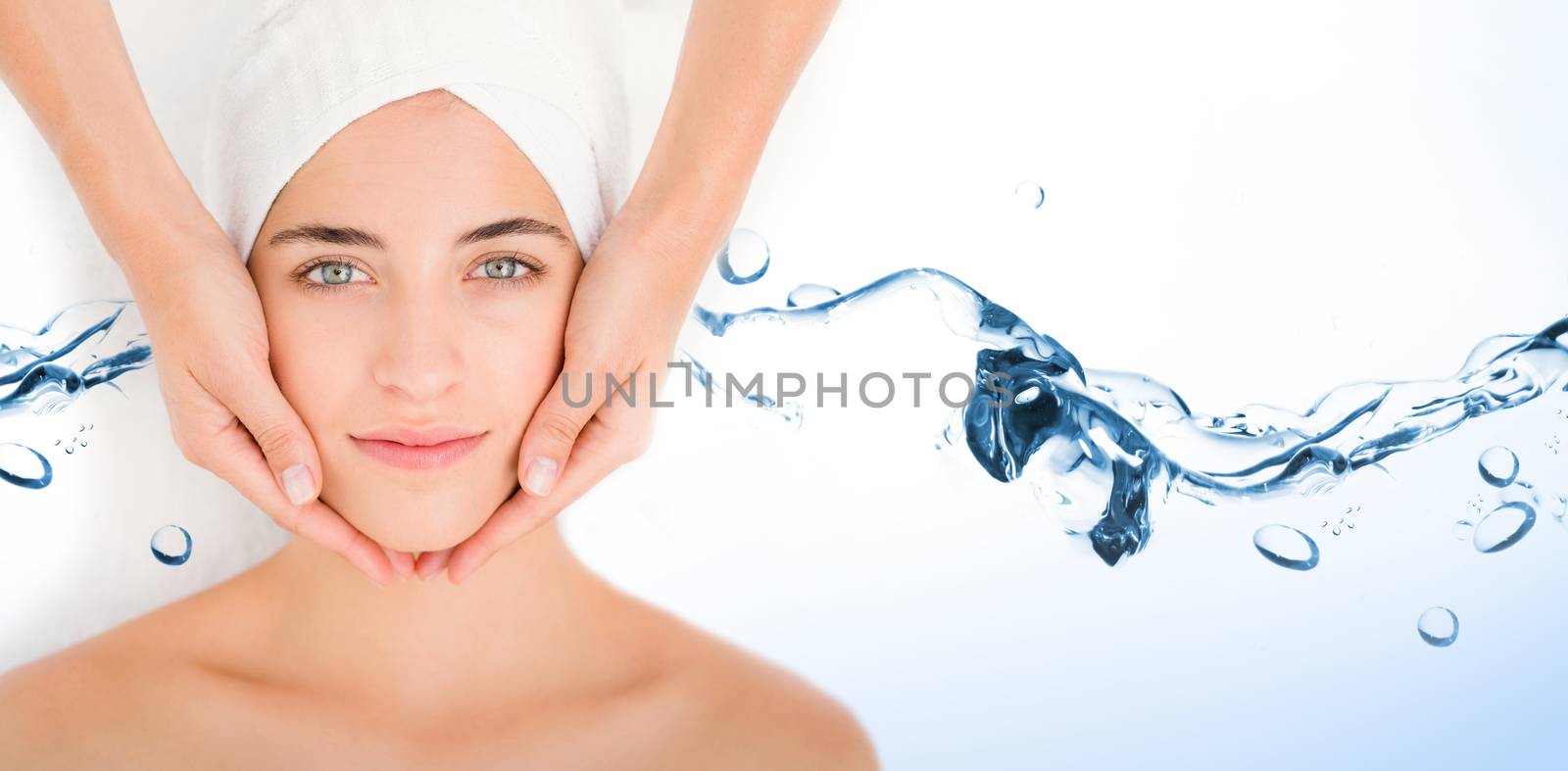 Water bubbling on white surface against attractive woman receiving facial massage at spa center