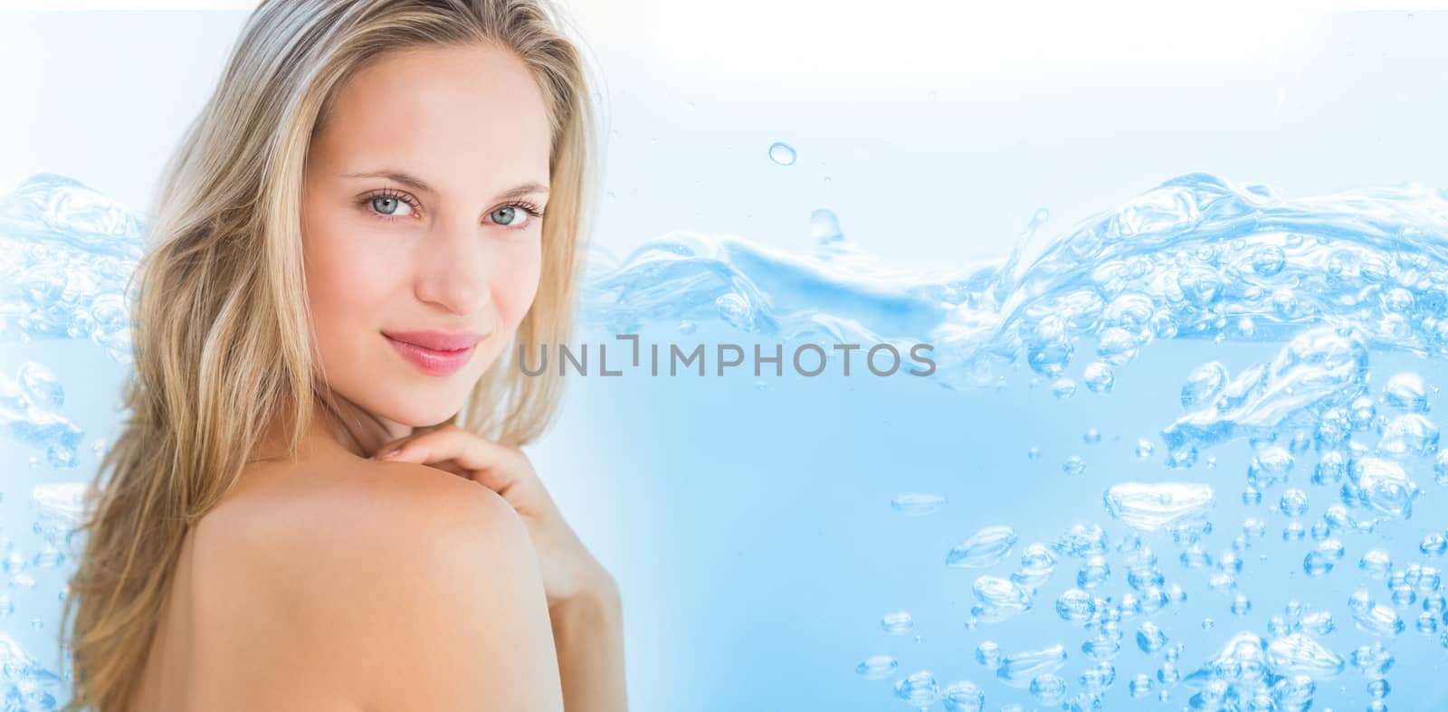 Close up on blue sparkling water against pretty blonde sitting on massage table