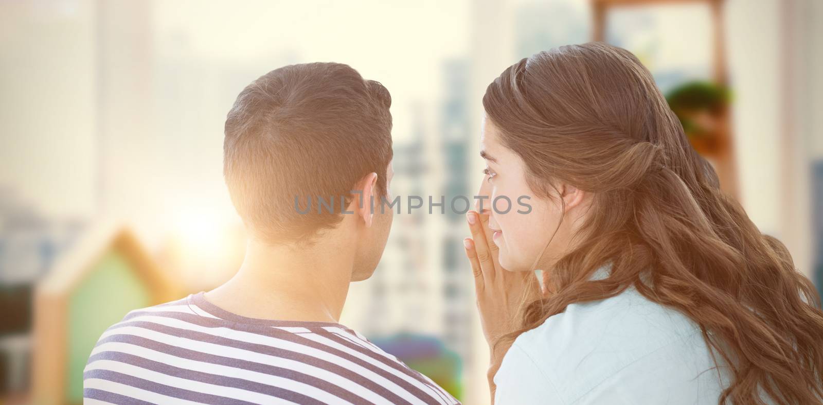 Woman whispering secret to boyfriend against view of a business desk 