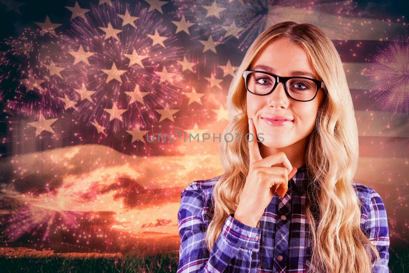 Gorgeous smiling blonde hipster thinking against composite image of colourful fireworks exploding on black background