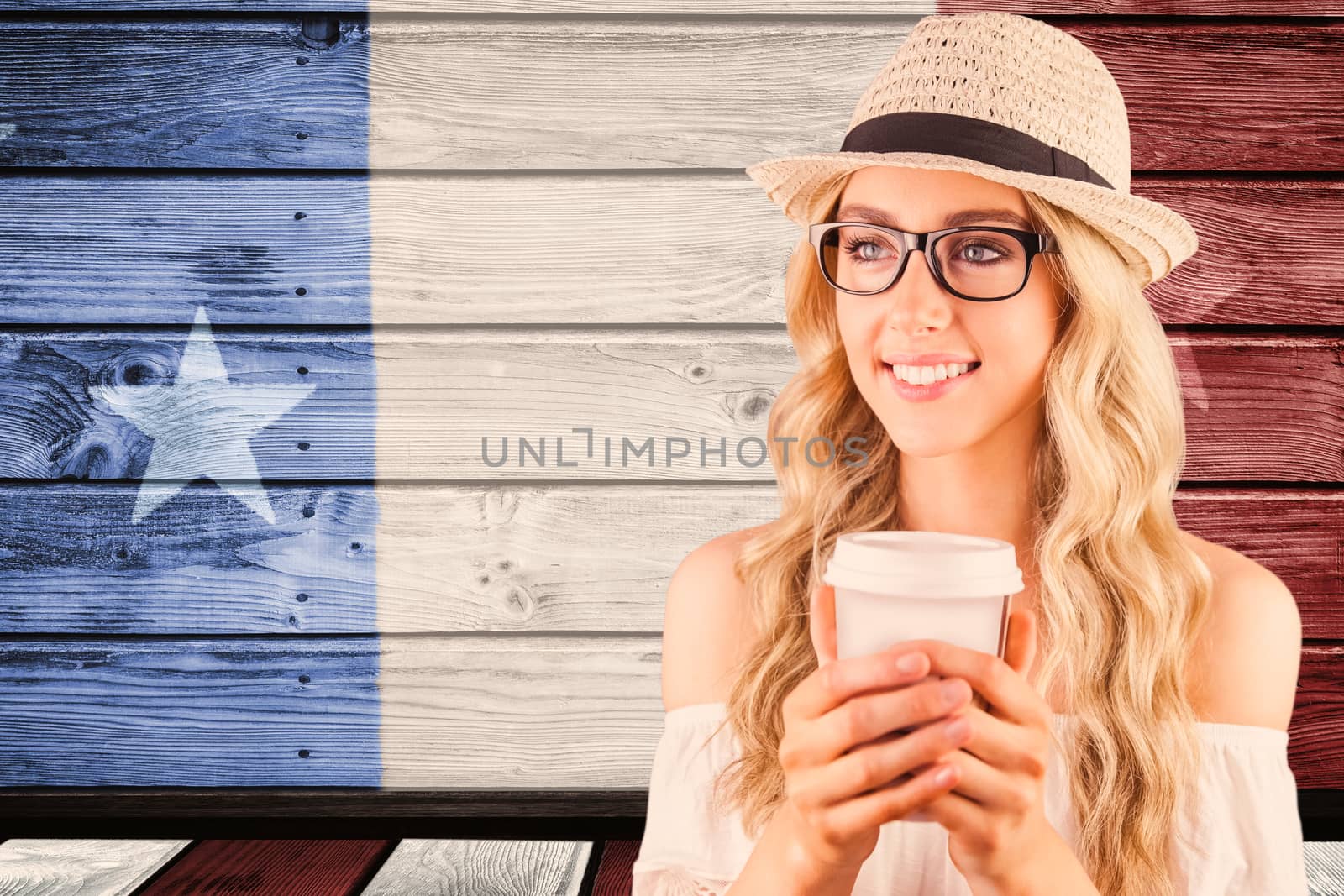 Gorgeous smiling blonde hipster holding take-away cup against composite image of usa national flag