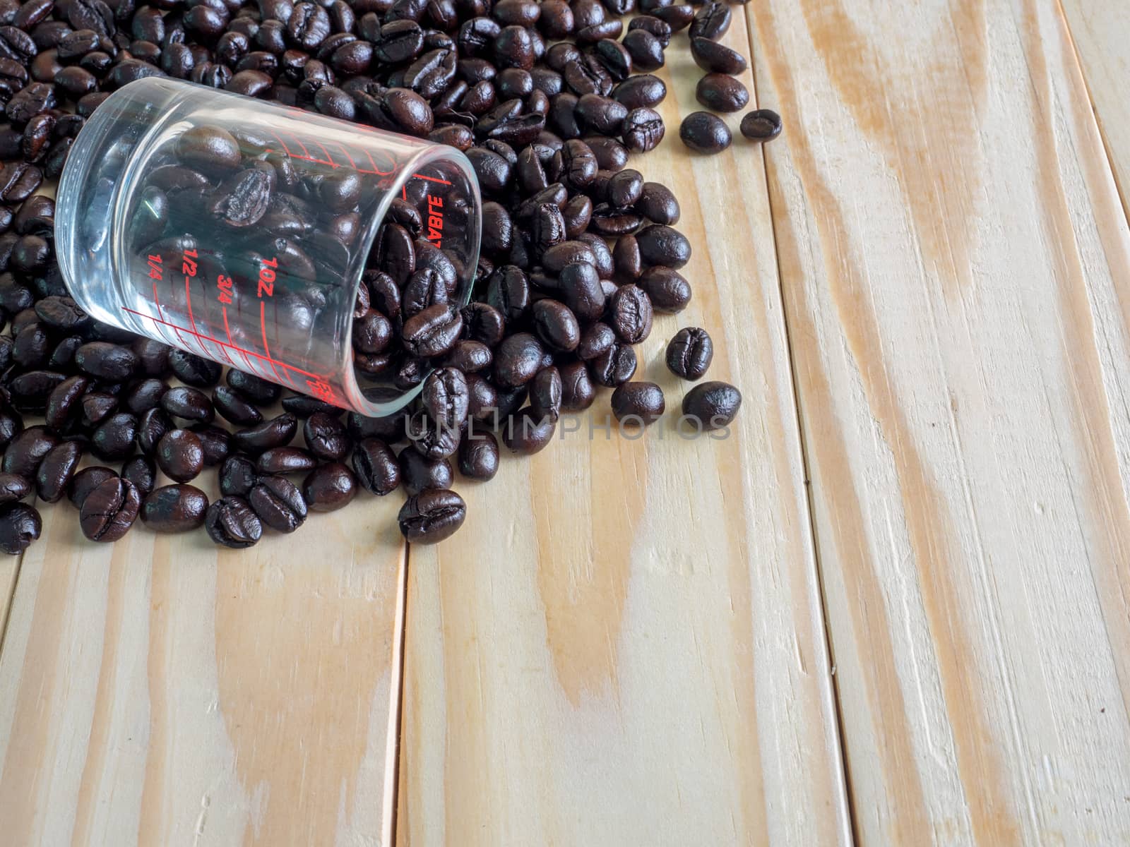 Coffee beans  and a measuring cup on wooden board