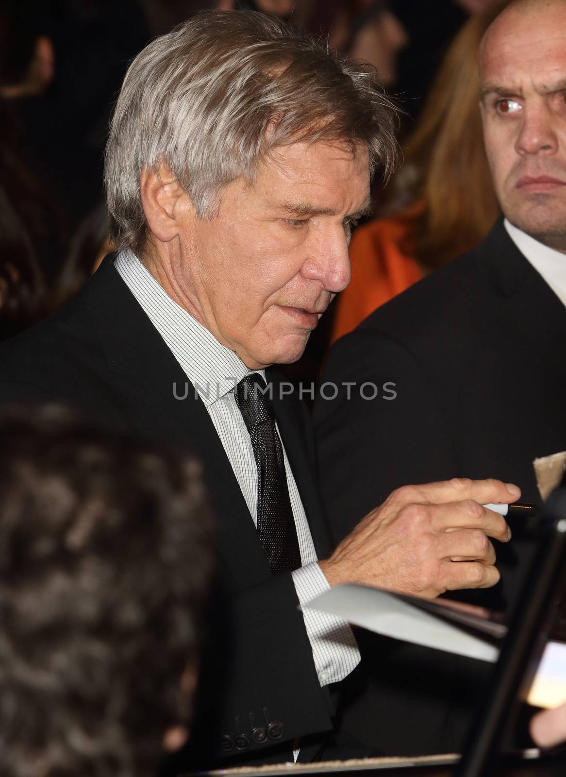 UNITED-KINGDOM, London :  Star Wars actor Harrison Ford signs autographs while Star Wars cast, crew and celebrities hit the red carpet for the last episode The Force Awakens European Premiere on December 16, 2015 in central London.   	