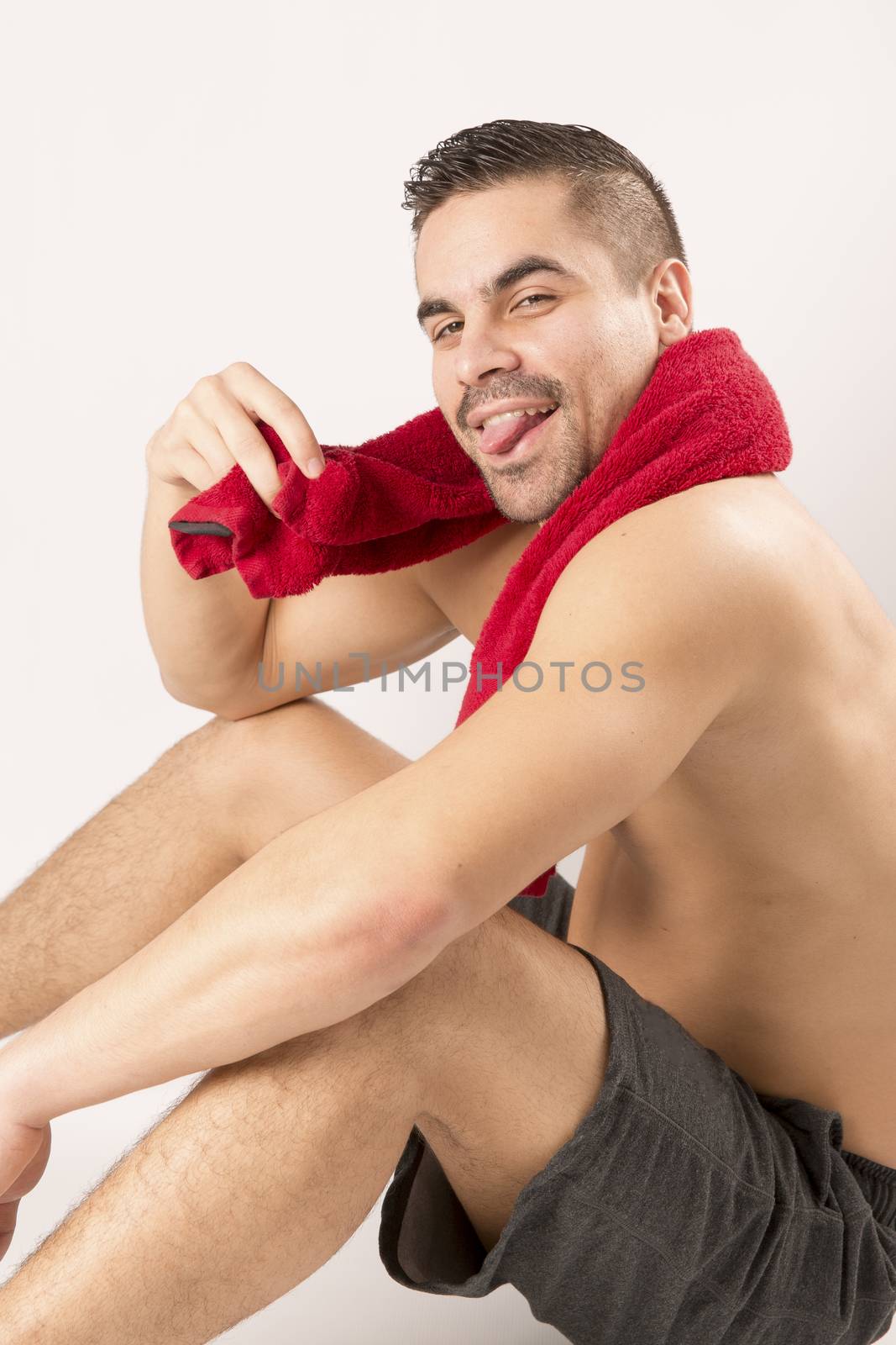 Muscle young man holding towel i on white background