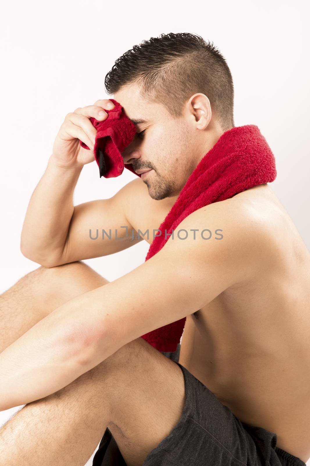 Muscle young man holding towel i on white background