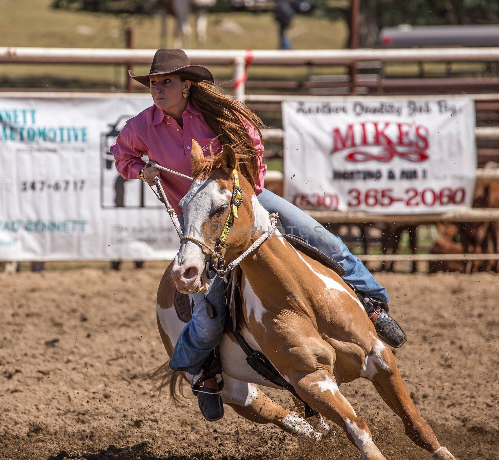 A barrel racer riders her horse to the next barrel. The rodeo in Cottonwood, California is a popular event on Mother's Day weekend in this small northern California town. This photo was taken in May, 2014.