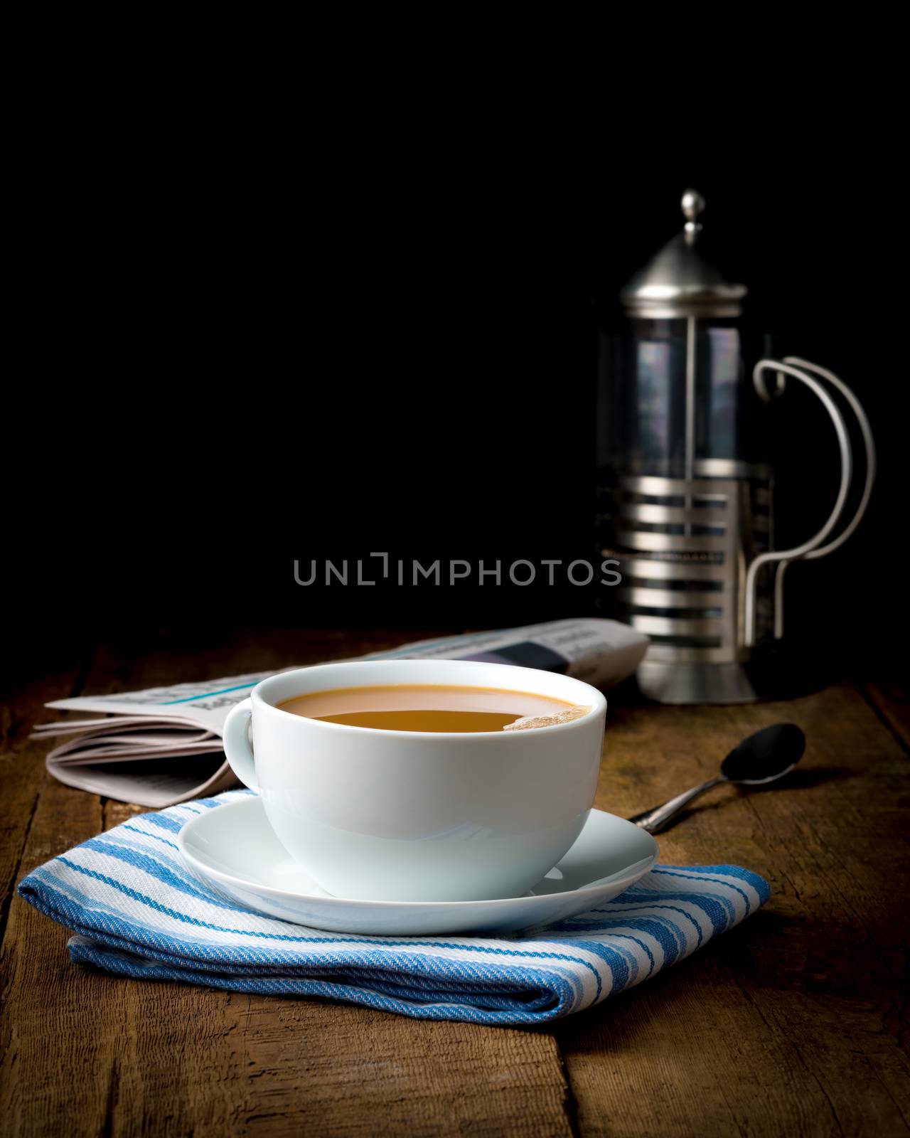 Cup of coffee with cream photographed on an artistic low key background.