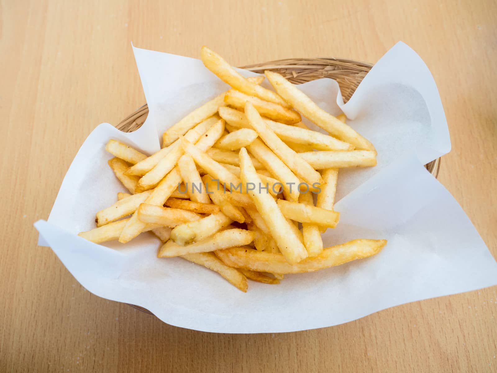 french fries in basket on wooden background