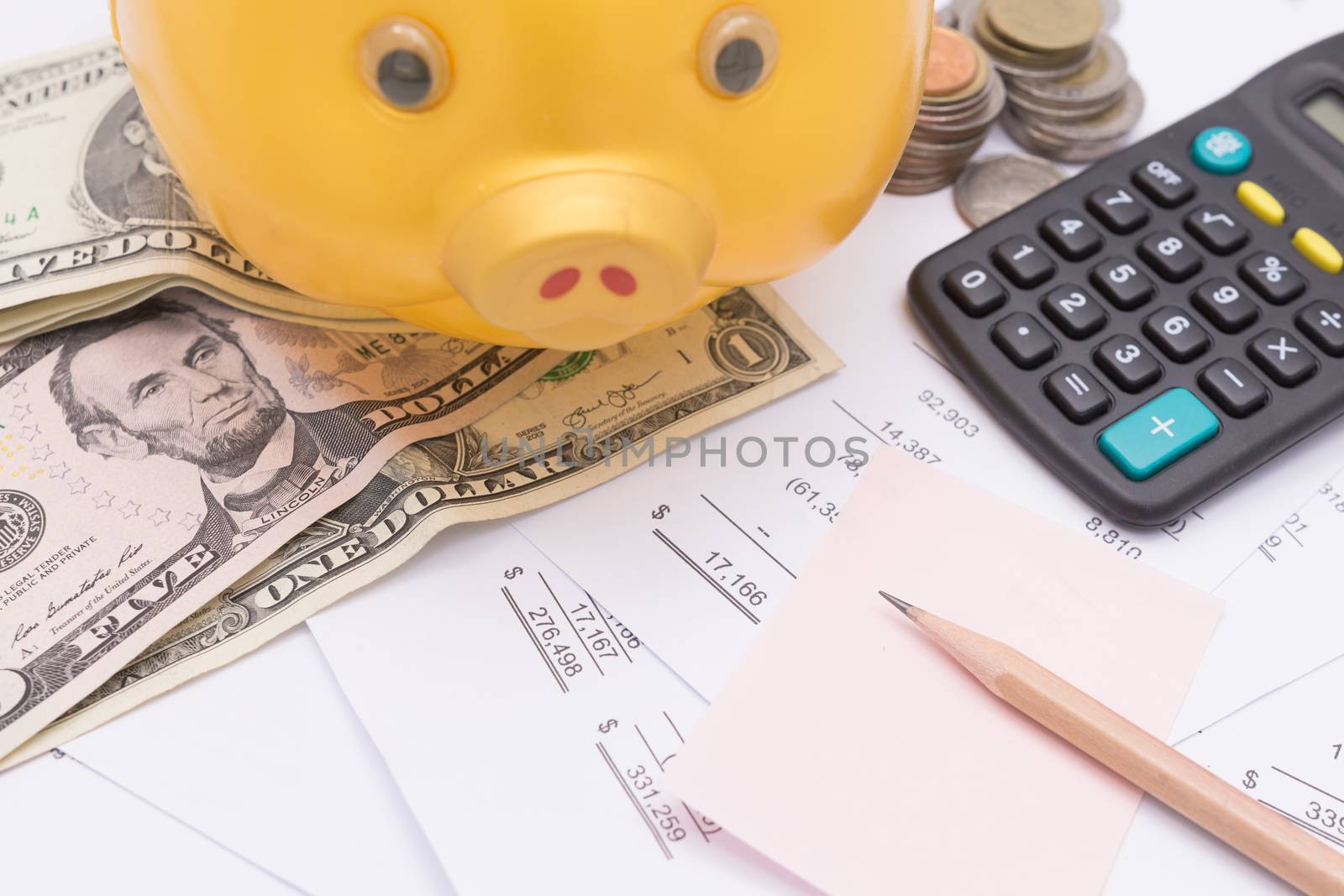 A piggy bank with money dollars and calculator  on financial report, savings