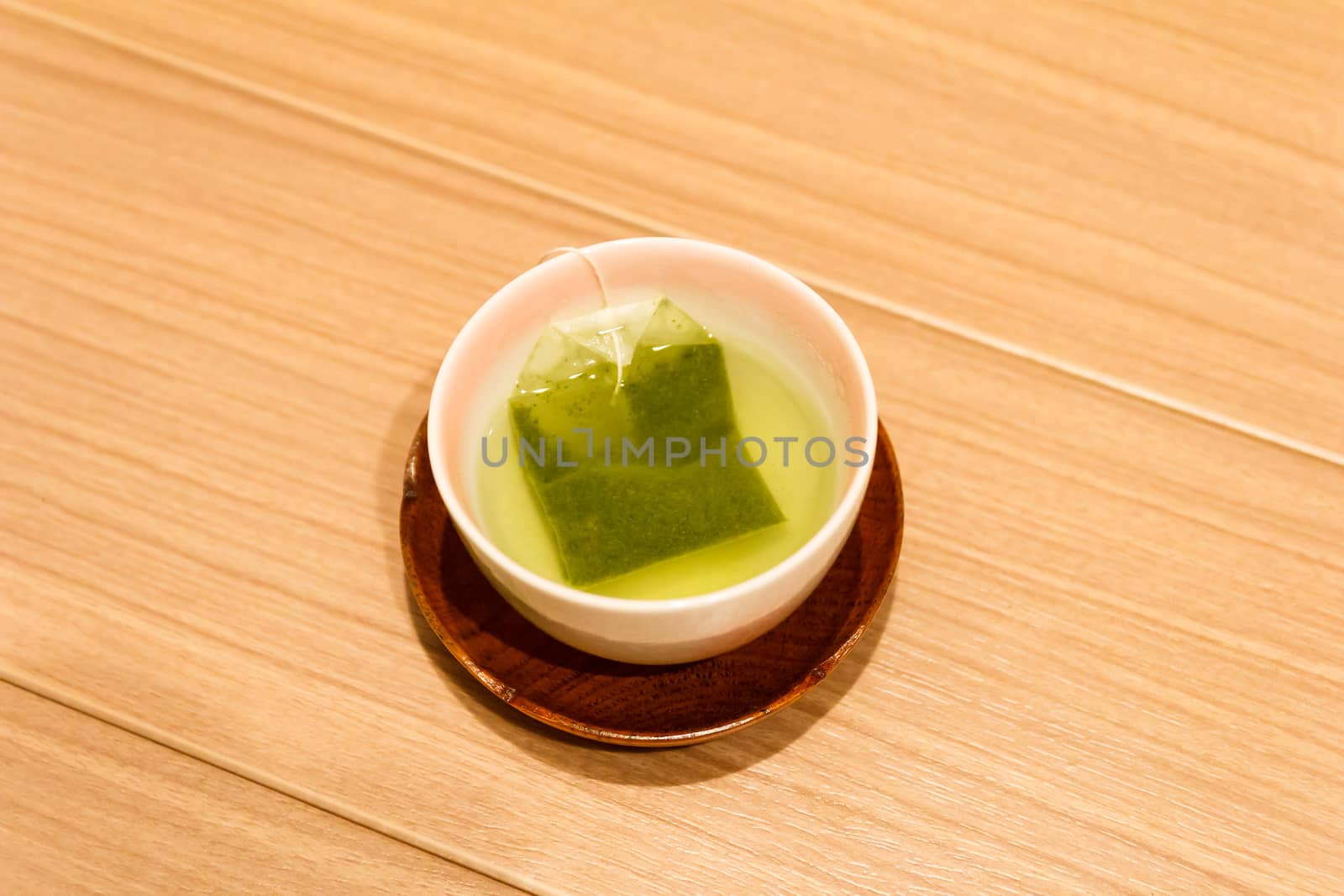 Green tea bag in japanese tea cup.