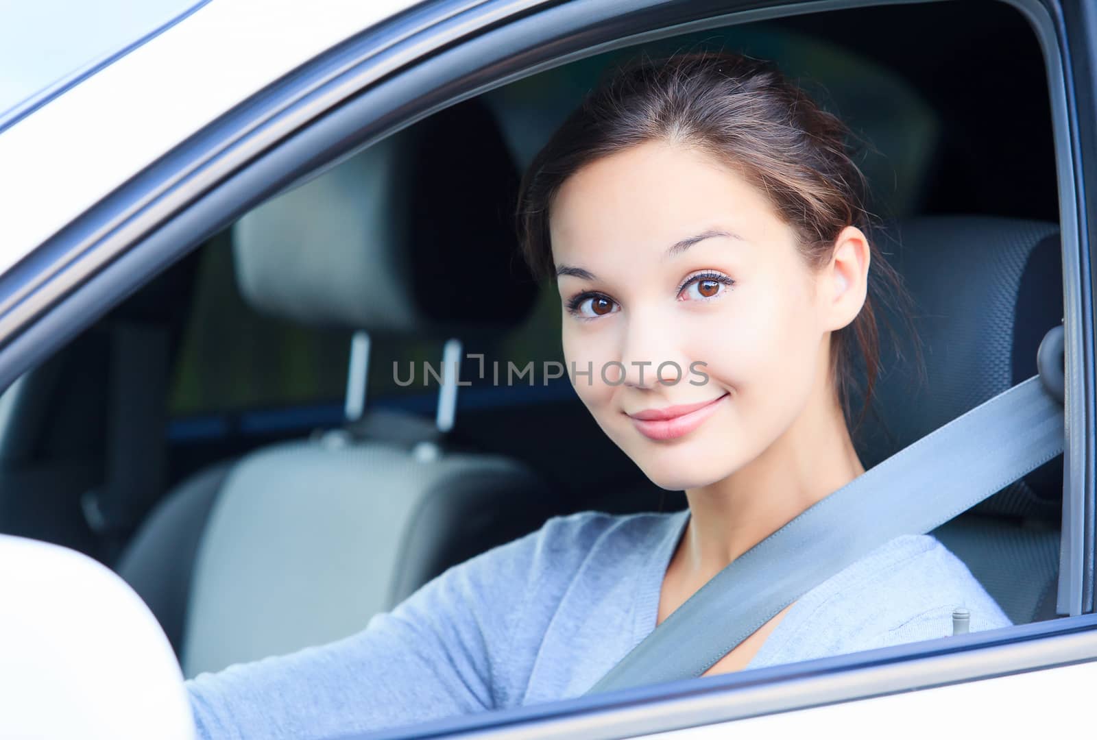 Girl in a car smiling to you.