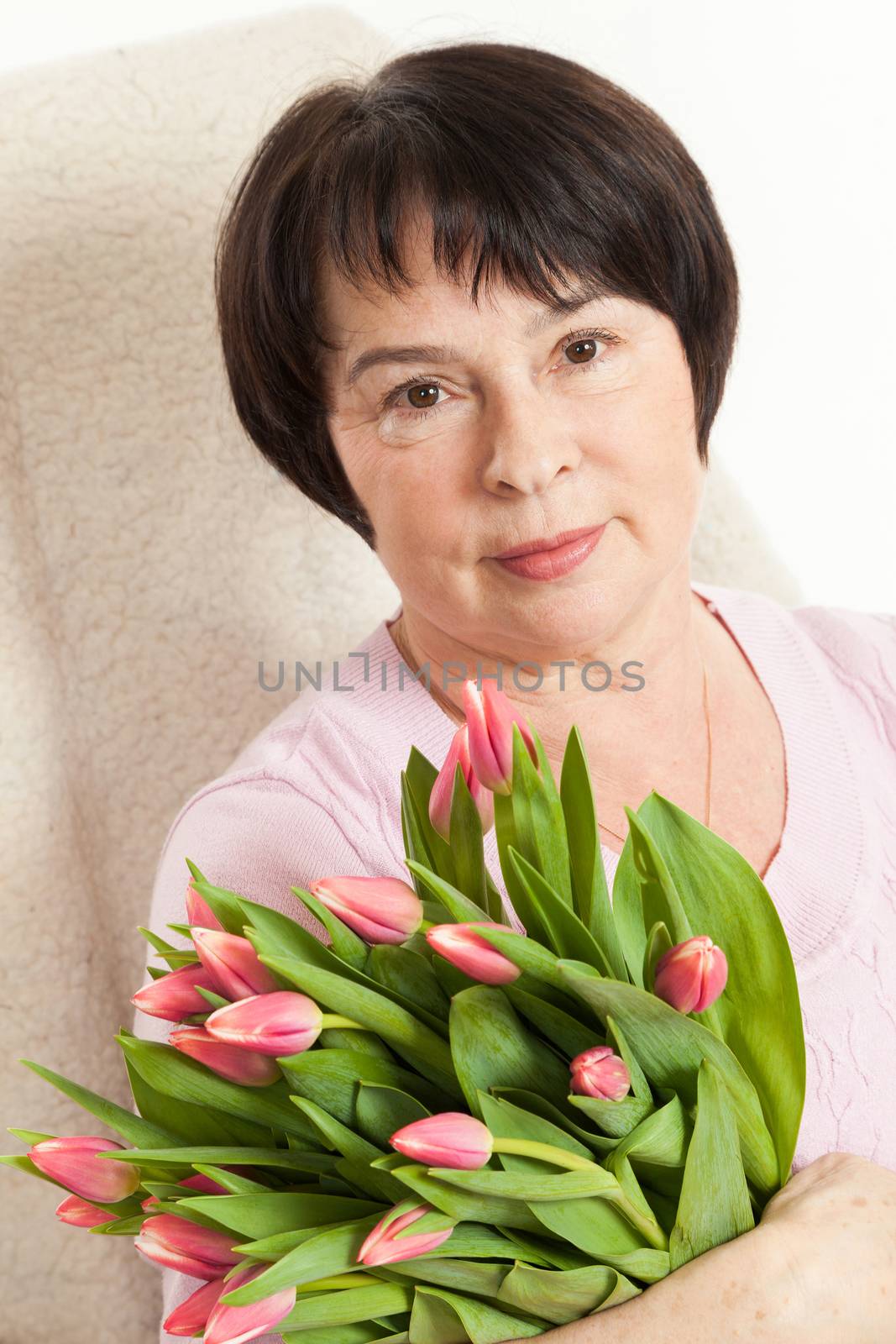 the beautiful mature woman with a bouquet of tulips