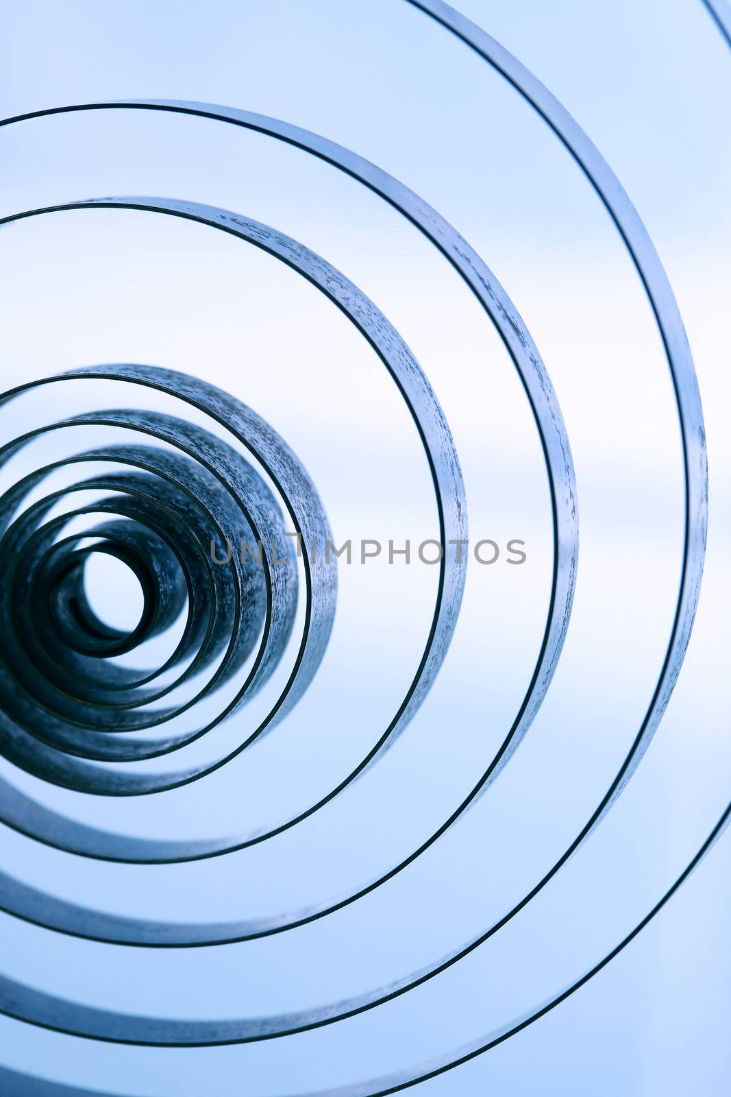 Industrial background. Closeup of old metal spiral on white background