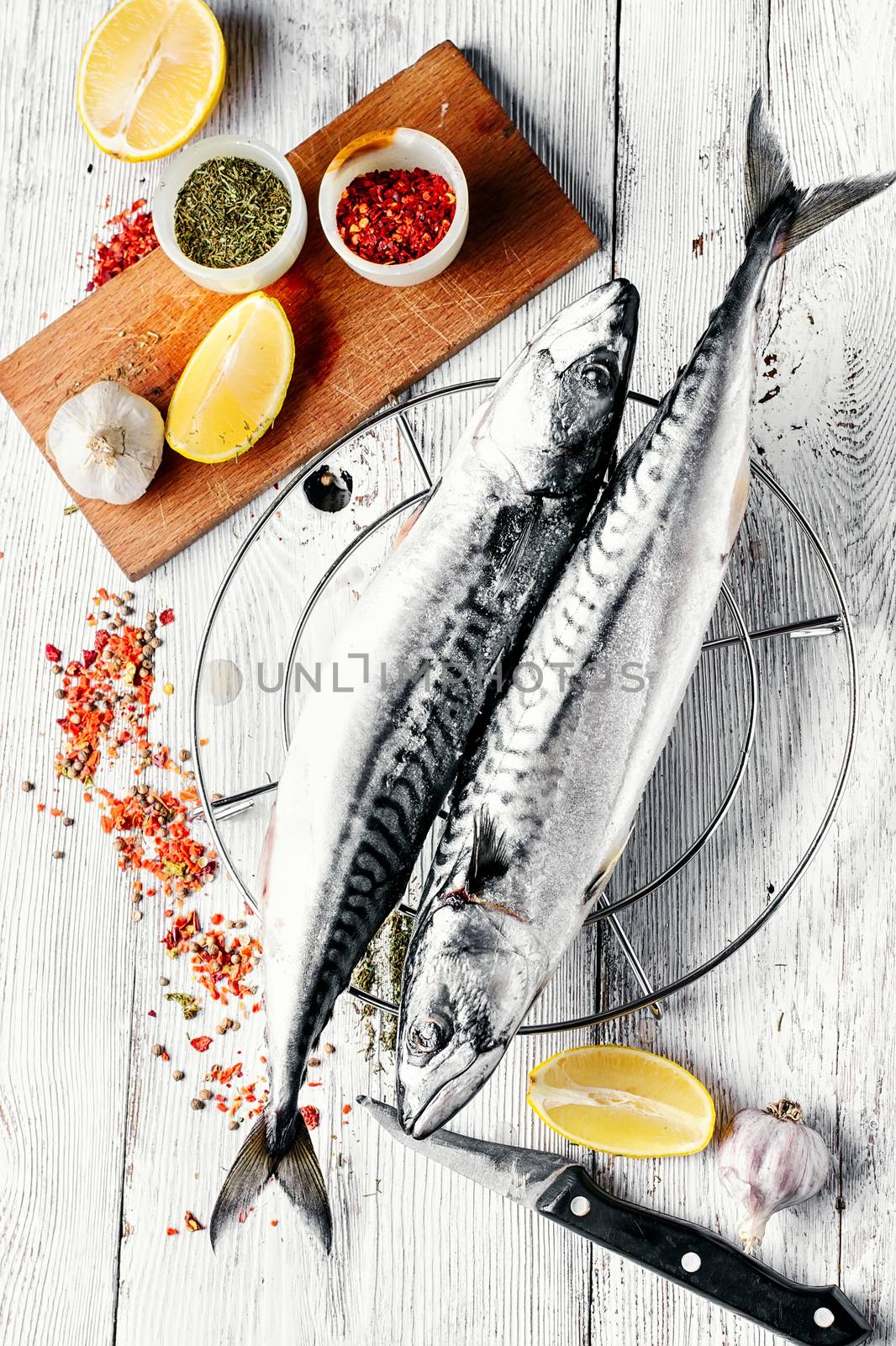 Thawed fresh fish mackerel with spices and marinade with lemon.Photograph high key.Top view