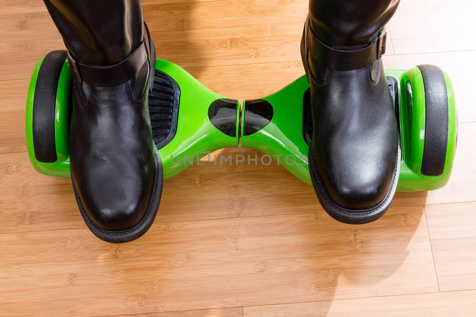 Close up of gyroscooter from front top view with riders feet over wooden floor