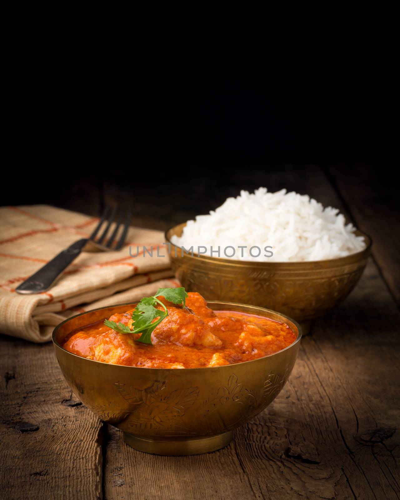 Indian butter chicken photographed with a low key background.