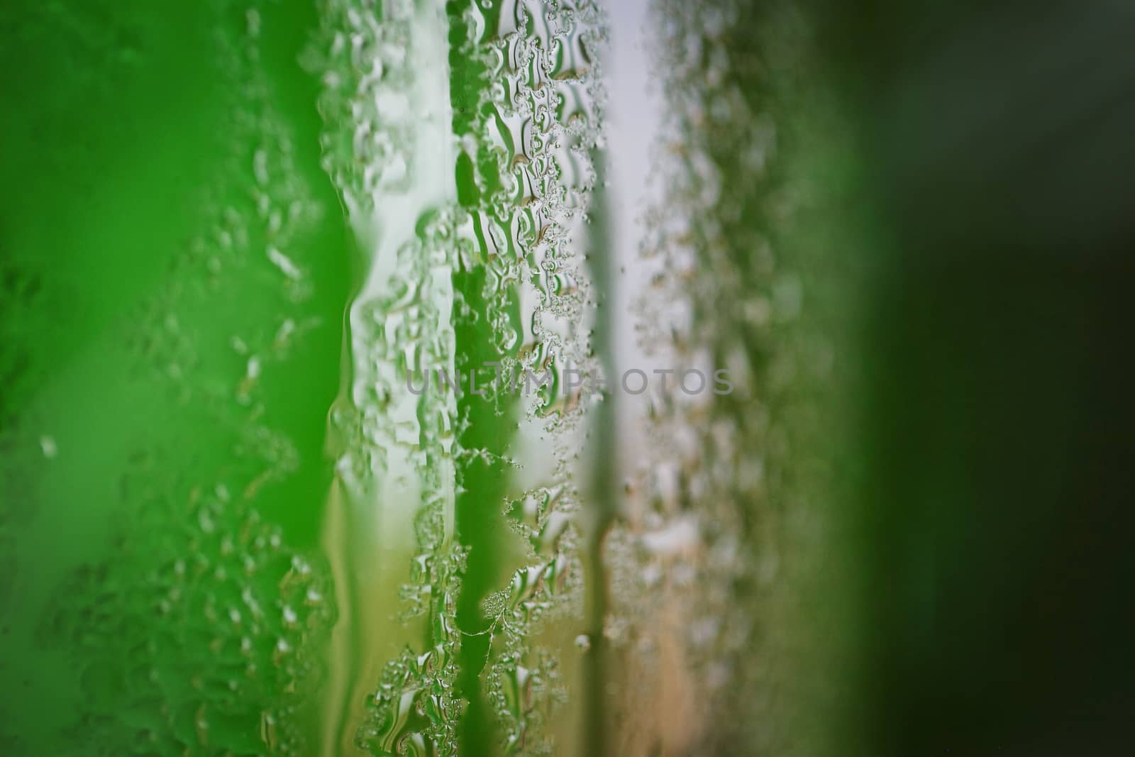 Green glass bottle with condensation on it