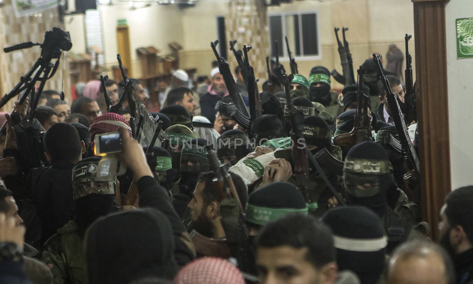 GAZA, Khan Yunis: [Warning: graphic content] Members of Hamas' Al-Qassam Brigades honor the fallen Marwan Maarouf during a funeral service in Khan Yunis, the Gaza Strip on February 9, 2016. The 27-year-old man was reportedly killed in one of several recent tunnel collapses in southern Gaza since late January.