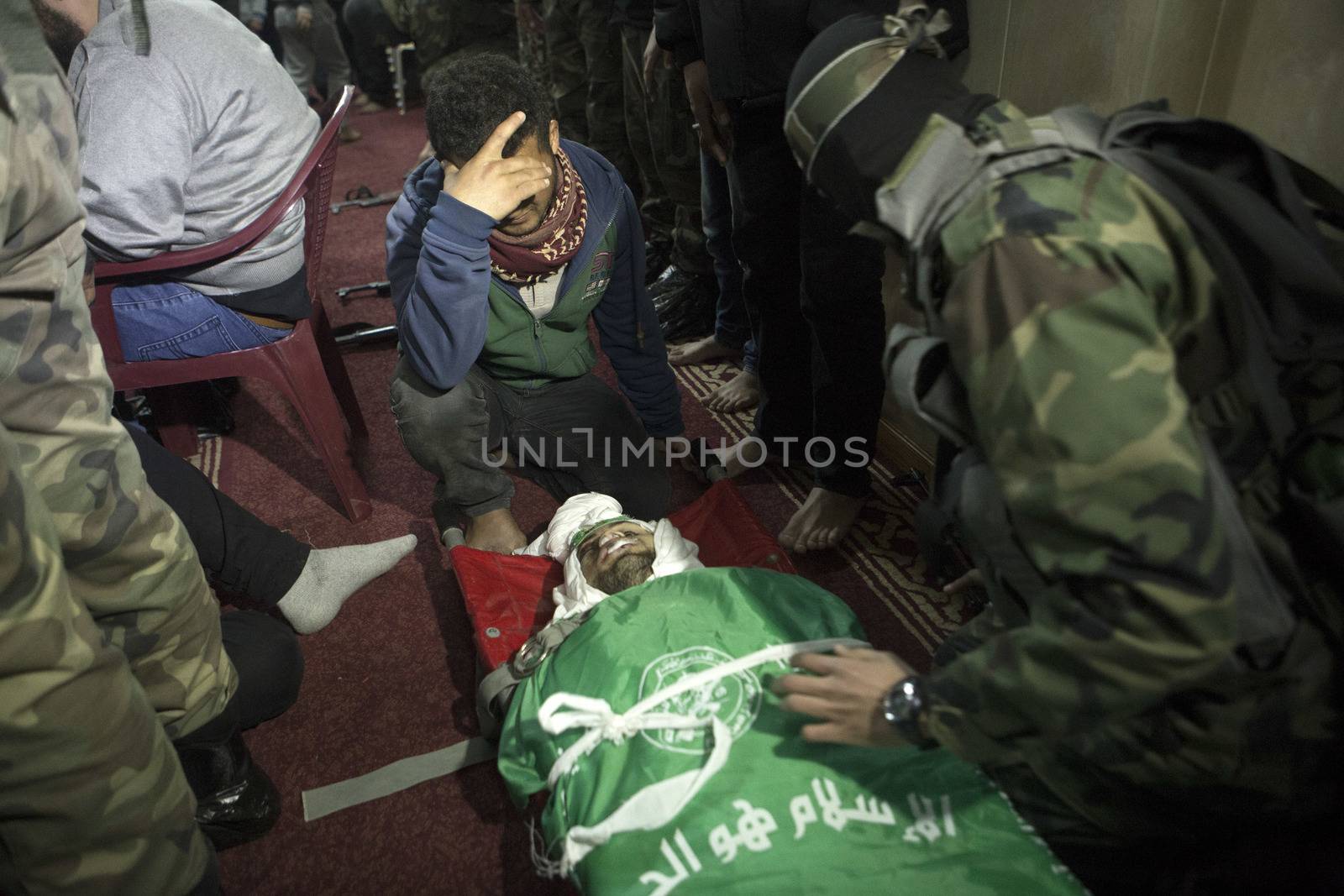 GAZA, Khan Yunis: [Warning: graphic content] A member of Hamas' Al-Qassam Brigades weeps as he honors the fallen Marwan Maarouf during a funeral service in Khan Yunis, the Gaza Strip on February 9, 2016. The 27-year-old man was reportedly killed in one of several recent tunnel collapses in southern Gaza since late January.