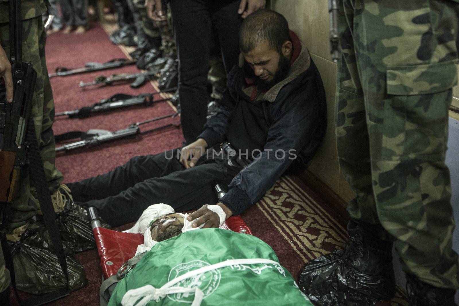 GAZA, Khan Yunis: [Warning: graphic content] A member of Hamas' Al-Qassam Brigades weeps as he honors the fallen Marwan Maarouf during a funeral service in Khan Yunis, the Gaza Strip on February 9, 2016. The 27-year-old man was reportedly killed in one of several recent tunnel collapses in southern Gaza since late January.