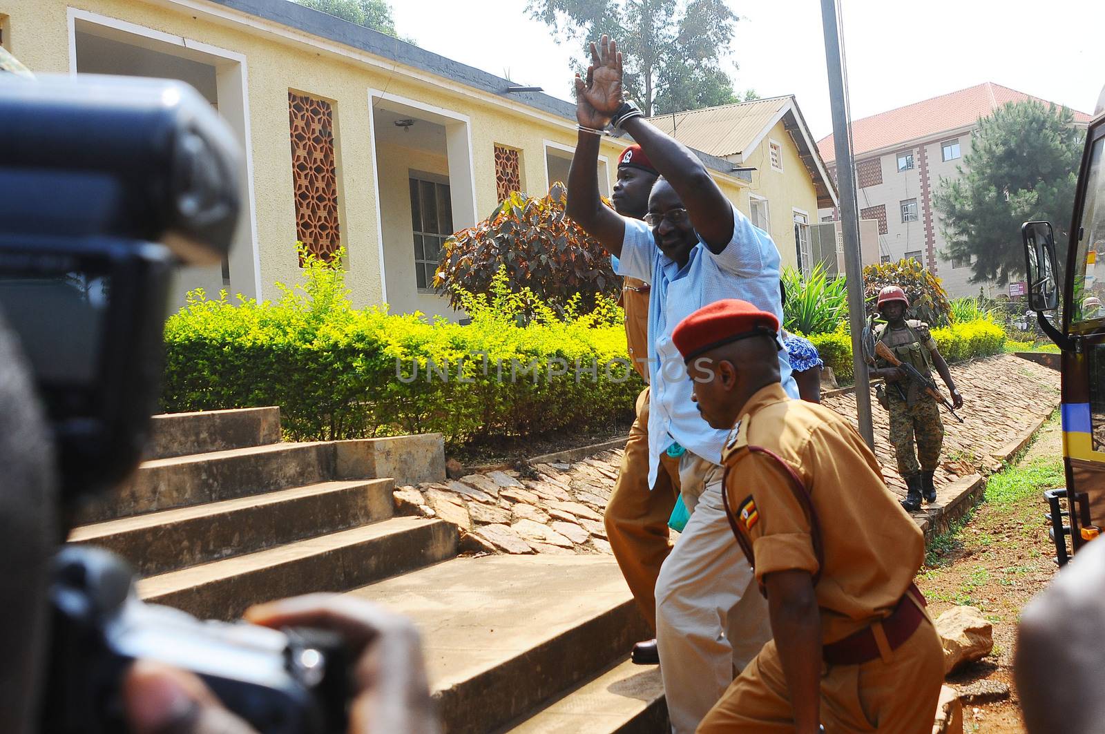 UGANDA, Kampala: David Sejusa flashes his handcuffs as he arrives at military court in Kampala, Uganda on February 9, 2016 where he would be denied bail as his case is adjourned until February 23. Sejusa was jailed after being charged the week previous with charges including absence without official leave, participating in partisan political activities, and insubordination.