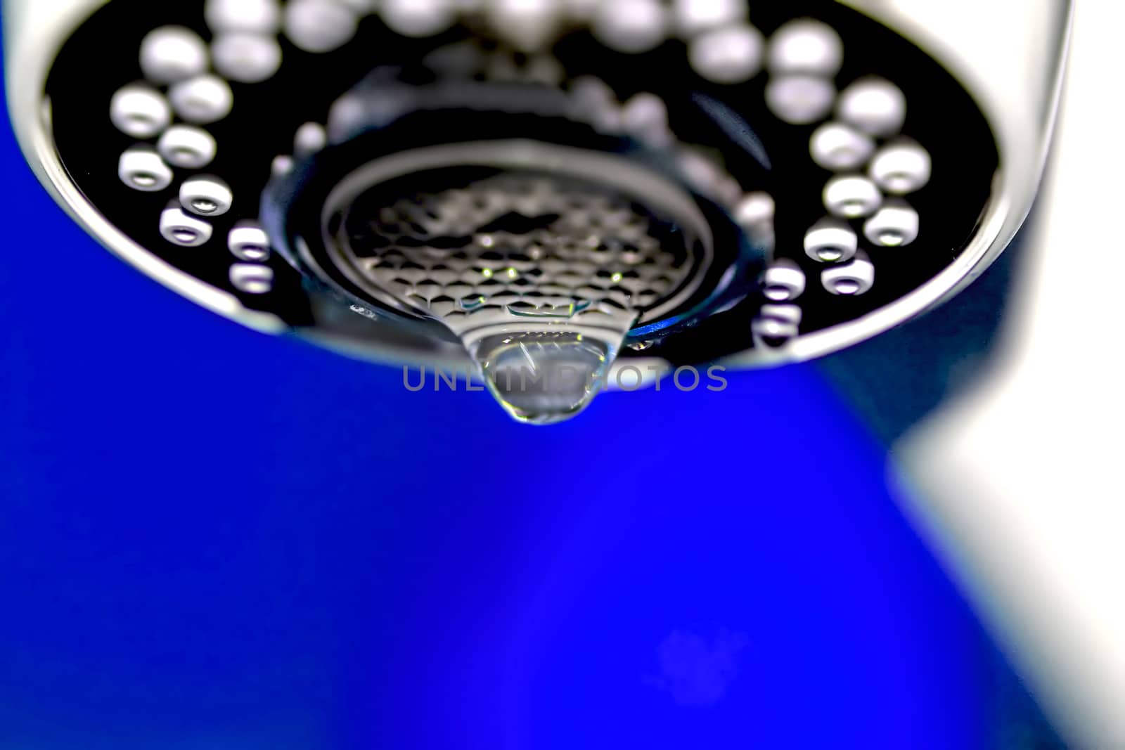 A macro of a white tap / faucet dripping.