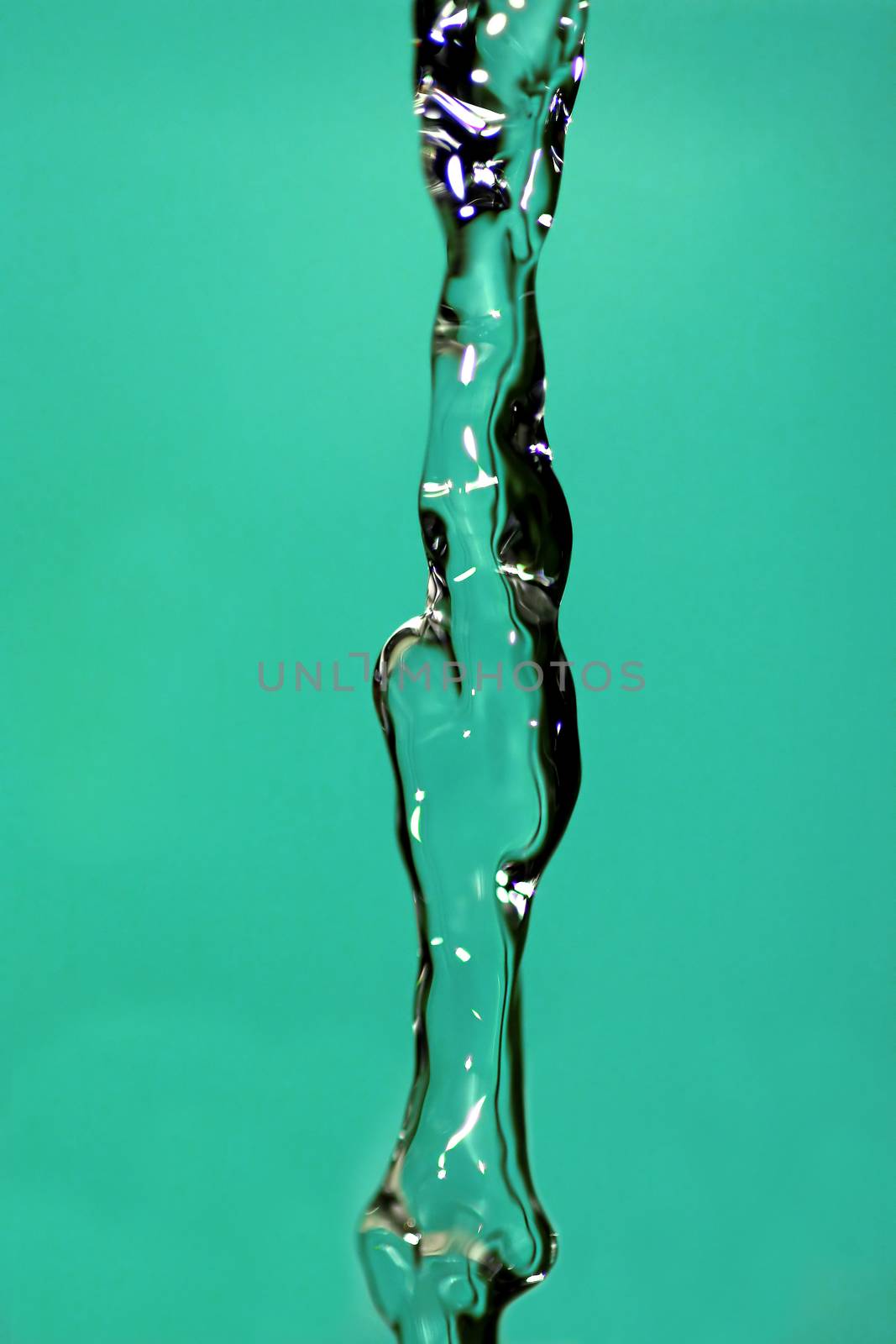 Water falling down, frozen in time with blue background.