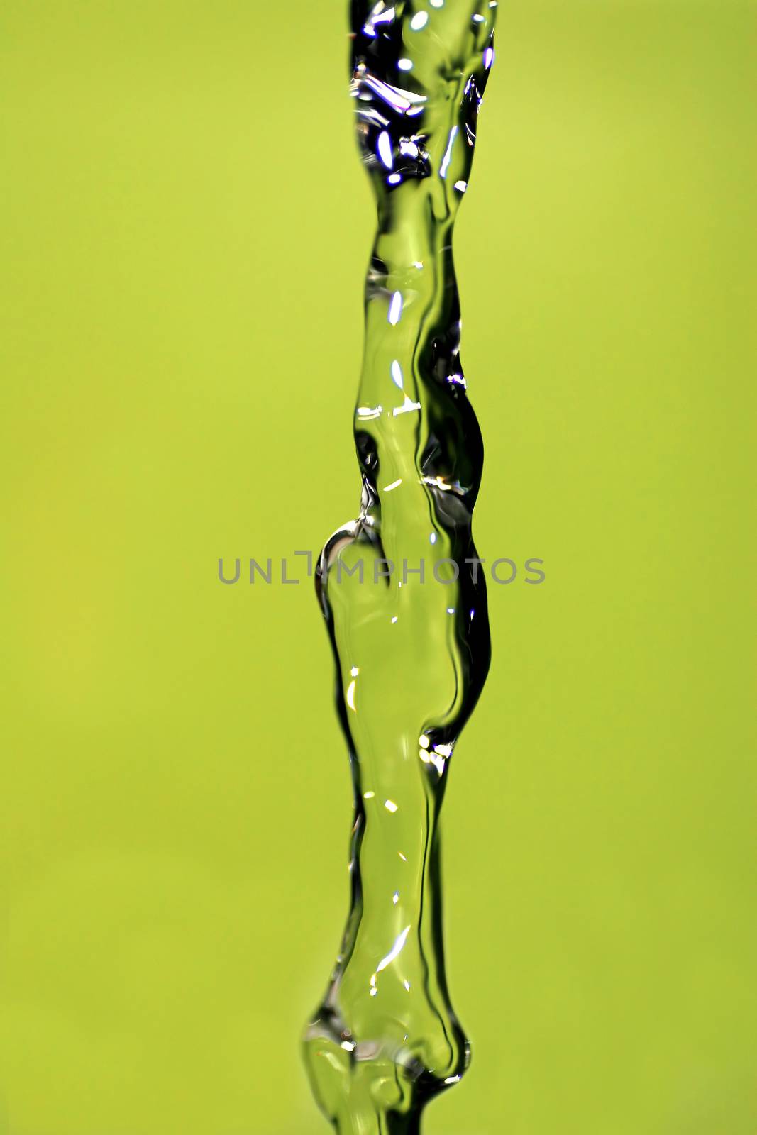 Water falling down, frozen in time with yellow background.