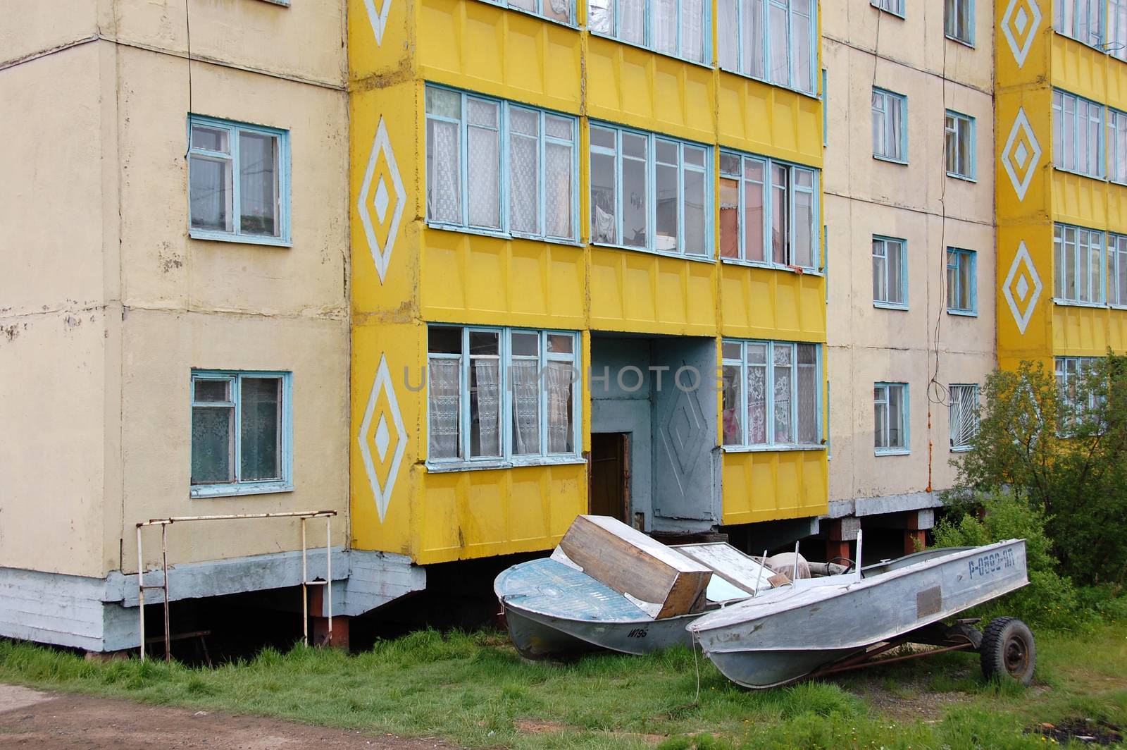 Boats at ground near apartment building, Chersky town,Yakutia, Russia