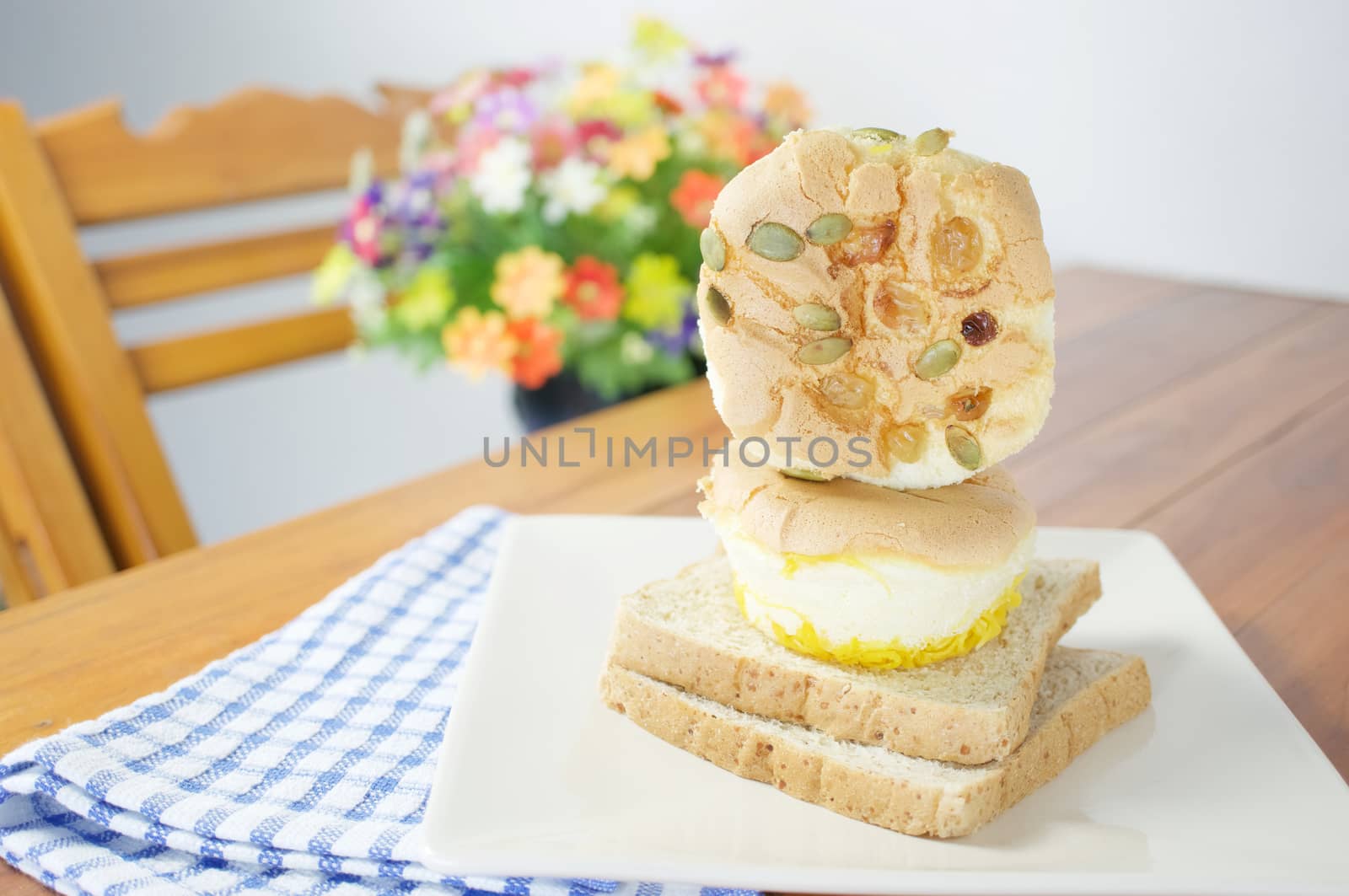 Pile of cup cake with pumpkin seeds and currant place in plate with bread on wood table with blue fabric.