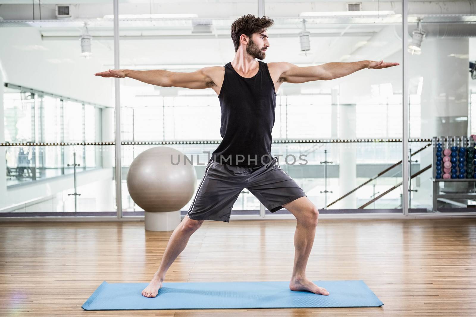 Handsome man doing yoga on mat by Wavebreakmedia