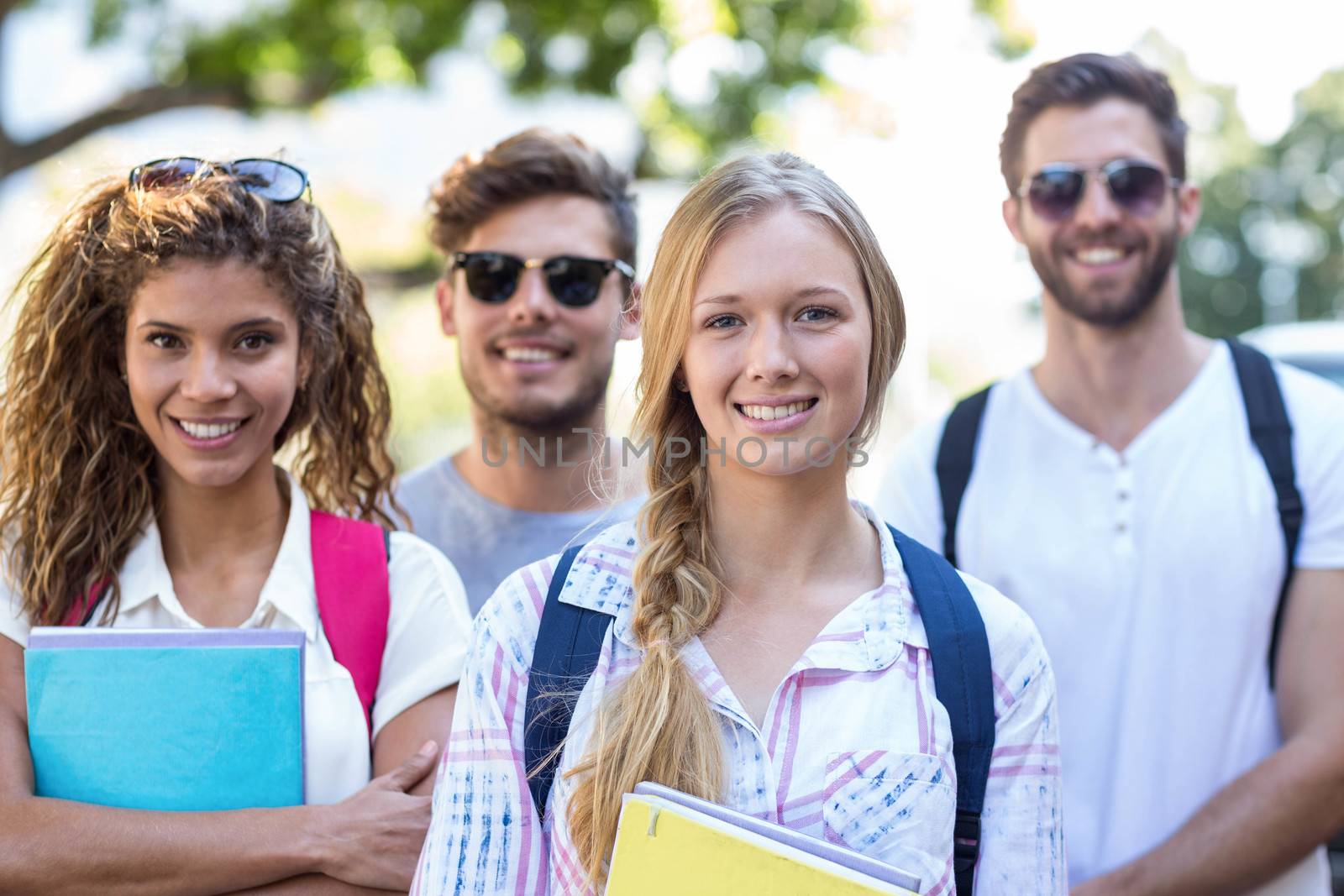 Hip friends holding notebooks and looking at the camera on the street