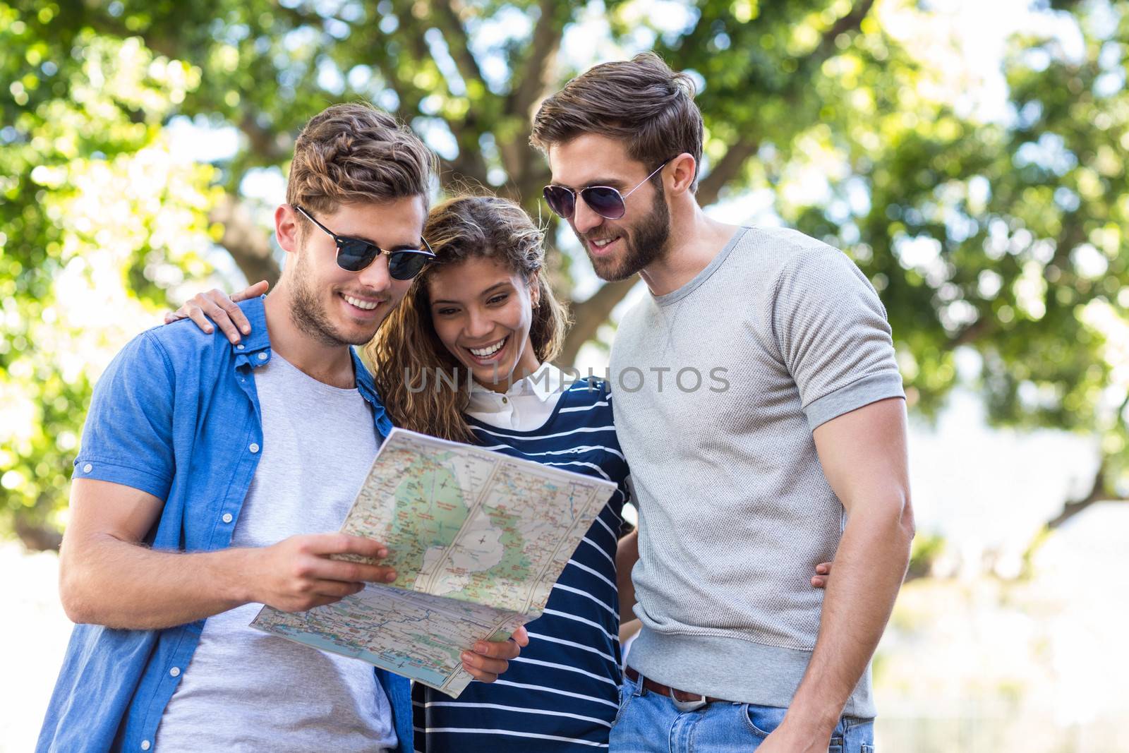 Hip friends checking map outdoors